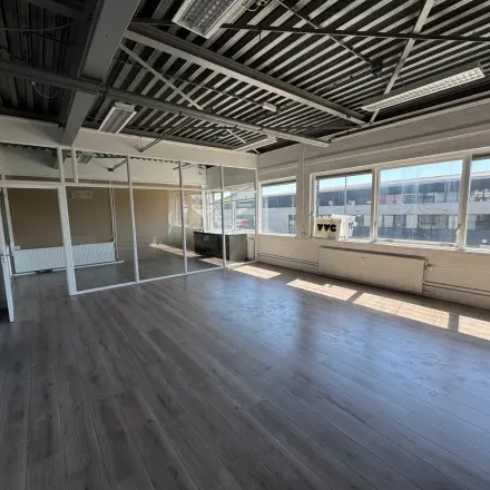 Spacious and sunlit office space with large windows, available for rental in Rotterdam Delfshaven at Van Helmontstraat. The area features natural light and potential for flexible workspace configurations.