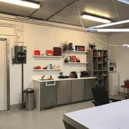 Furnished office space at Van Helmontstraat 17-23, Rotterdam Delfshaven, featuring a kitchenette with shelves, a microwave, and a coffee maker, ideal for your next office space rental.