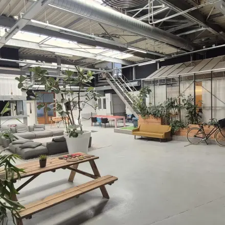 Spacious open-floor office at Van Helmontstraat 17-23 in Rotterdam Delfshaven, featuring a bright, airy workspace with modern furnishings, plants, and bikes, ideal for office space rental.