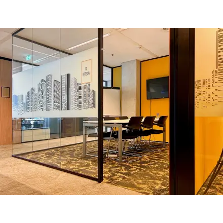 Modern furnished office space for rent at Wilhelminakade 173, Rotterdam Kop van Zuid, featuring a glass-enclosed conference room with a city skyline design and a large table with chairs.