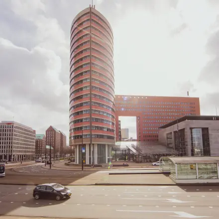 Exterior view of the iconic cylindrical office building at Wilhelminaplein 1-40, ideal for an office space rental in Rotterdam Kop van Zuid.