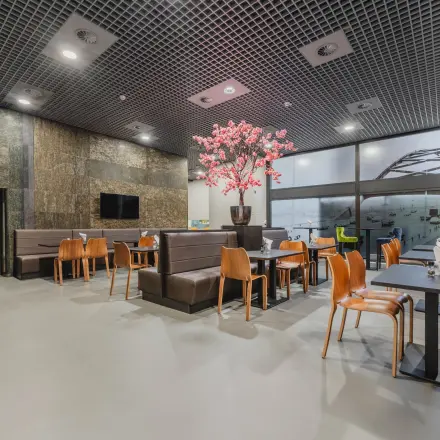 Spacious and modern office lounge with seating arrangements and decorative elements, ideal for office space rental.