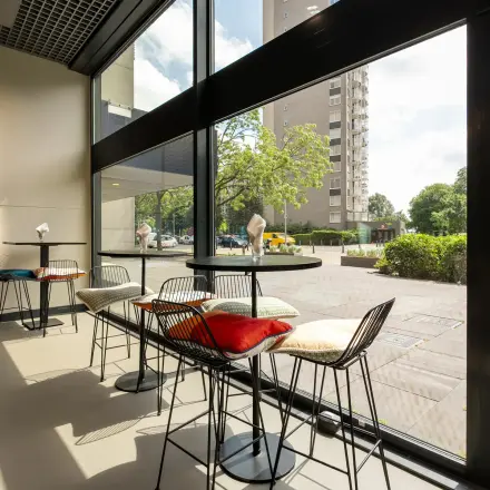 Bright office space with high windows and modern chairs at Oostmaaslaan 71, perfect for office space rental in Rotterdam Kralingen.
