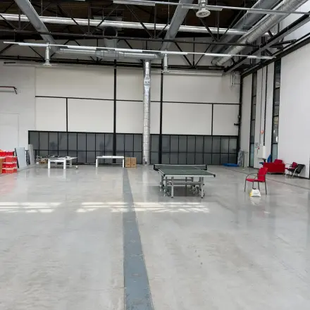 Spacious office area available for rent in Rotterdam Waalhaven, featuring high ceilings, large windows, and minimal furnishings, ideal for versatile workspace configurations.