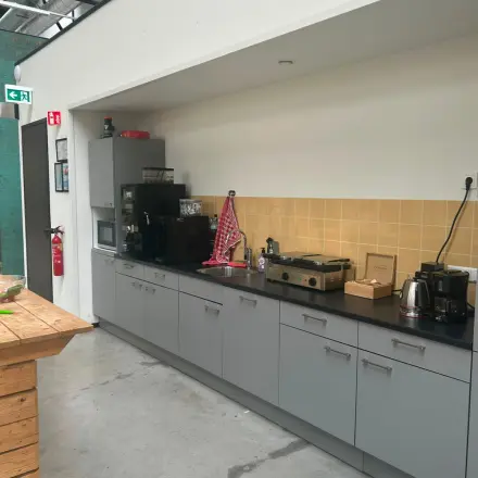 Furnished office pantry at Scheepsbouwweg 29, Rotterdam Waalhaven featuring gray cabinets and appliances. Ideal for office space rental.