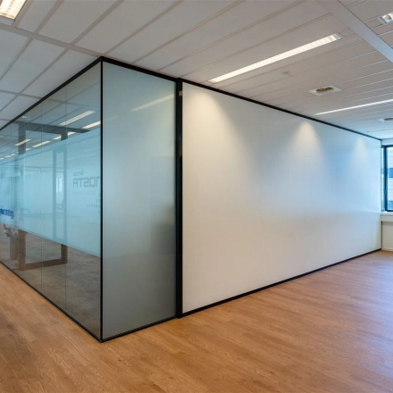 Bright office space at Waalhaven O.z. 83 in Rotterdam featuring glass-walled rooms and wooden flooring, suitable for office space rental.