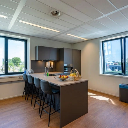 Bright office space featuring a modern pantry with bar stools and large windows at Waalhaven O.z. 83, Rotterdam Waalhaven, ideal for office space rental.