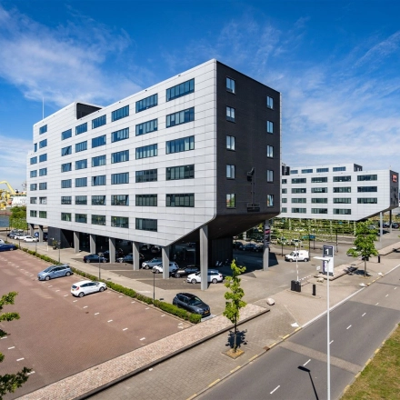 Office building exterior at Waalhaven O.z. 83 in Rotterdam Waalhaven with ample parking space, ideal for office space rental.