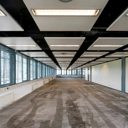 Unfurnished office space with large windows and modern ceiling design, available for rent at Folkstoneweg 2-56, Schiphol Airport.