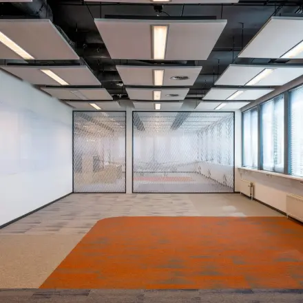 Spacious office for rent at Schiphol Airport with unique ceiling design and vibrant flooring, ideal for office space rental.