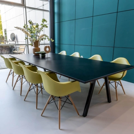 Modern office space rental at Beechavenue 54-100, Schiphol Rijk featuring a long table with vibrant chairs and decorative elements, perfect for collaborative meetings.