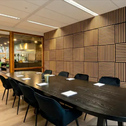 Modern conference room with a large wooden table and upholstered chairs available for office space rental at Boeing Avenue 1-19, Schiphol Rijk.