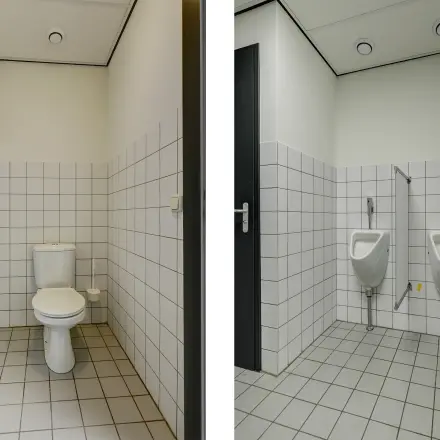 Office restroom at Fischerpad 106 in Sittard, available for office space rental, featuring tiled walls and modern fixtures.