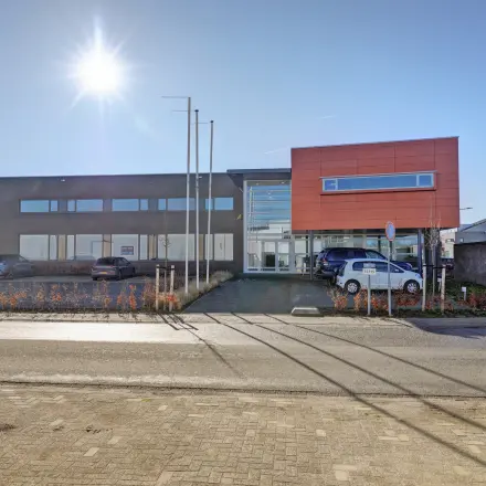 Exterior view of the office building at Fischerpad 106 in Sittard, available for office space rental, showcasing modern architecture with ample parking space.