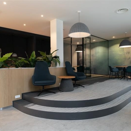 Modern office interior at Alexanderveld 5-9, The Hague Center featuring stylish furnishings and a meeting area, ideal for office space rental.
