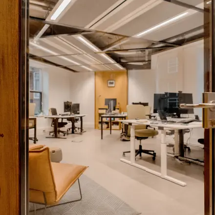 Modern office space with several desks and office chairs, computers set up, located at Fluwelen Burgwal 58 in The Hague Center, available for office space rental.