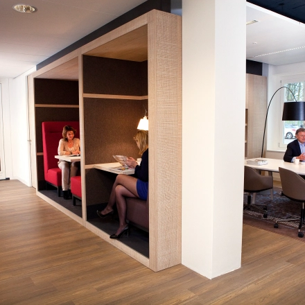 Cozy office space at Koninginnegracht 19 in The Hague Center, showcasing collaborative work areas with professionals engaging in discussions and tasks. Ideal for those looking to rent office space in a modern setting.