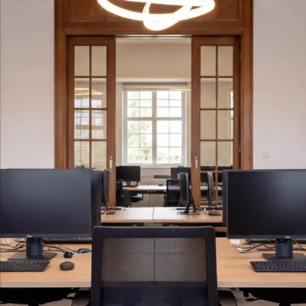 Modern office space rental with ample desks and computers, located at Mauritskade 9 in The Hague Center.