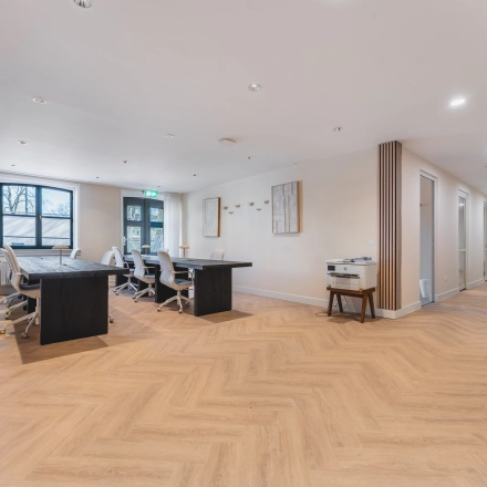 Spacious office with modern furnishings including several desks and chairs at Zeestraat 100, The Hague Center, ideal for office space rental.