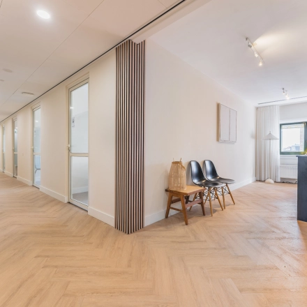 Bright office space at Zeestraat 100, The Hague Center available for rent, featuring stylish seating and a small refreshment area.