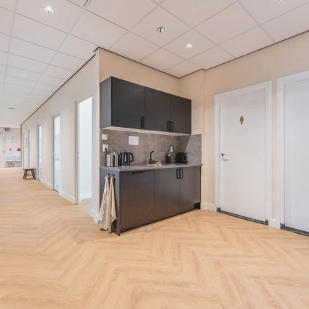 Bright office space with a kitchenette in Zeestraat 100, The Hague Center, available for rent. The corridor leads to various rooms, ideal for any office space rental needs.