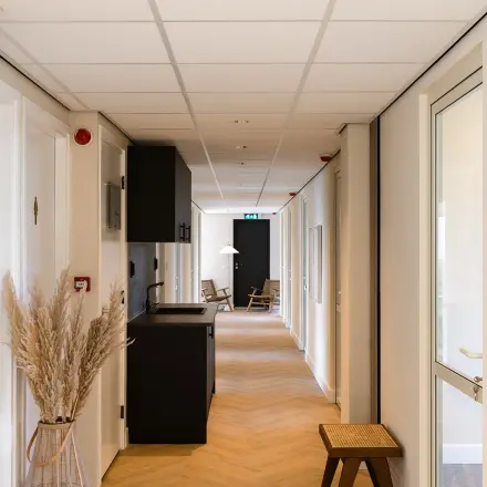 Hallway at Zeestraat 100 in The Hague Center with seating and natural decor, ideal for office space rental.