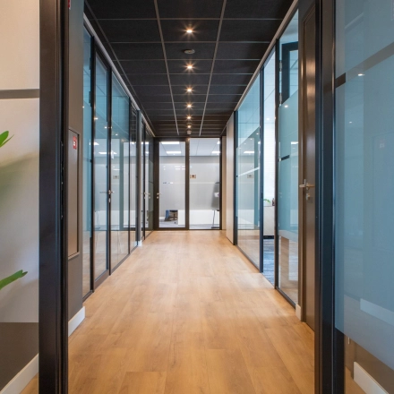 Bright office hallway with glass doors and wooden floors at Kapitein Rondairestraat 8, Tilburg, perfect for office space rental.