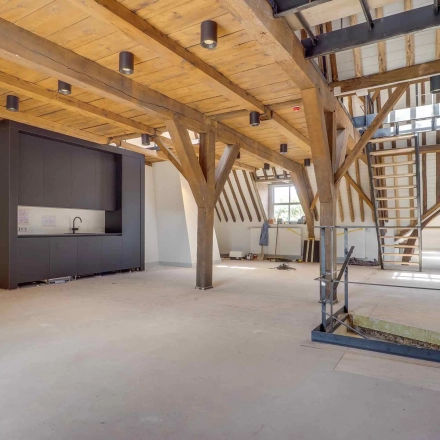 Spacious office interior with wooden beams and a kitchenette, located at Brigittenstraat 22 in Utrecht Center, ideal for office space rental.