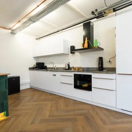 Modern office kitchenette with sleek cabinetry and appliances at Oudegracht 161, ideal for office space rental in Utrecht Center.