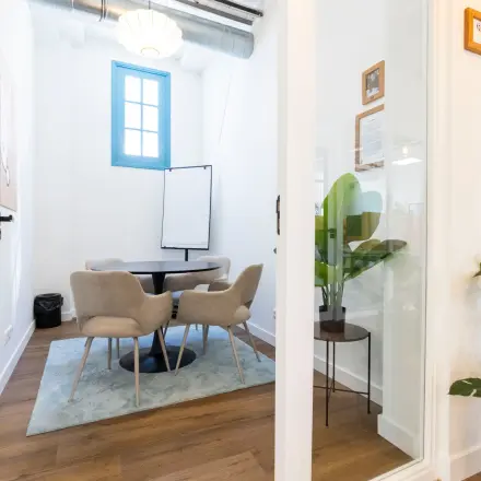 Bright office to rent at Oudegracht 161, Utrecht Center, featuring a small conference table surrounded by modern chairs and a flip chart in a cozy corner.