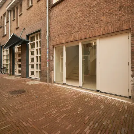 Exterior view of available office space for rent at Oudegracht 161, Utrecht Center, featuring a brick facade and large windows.