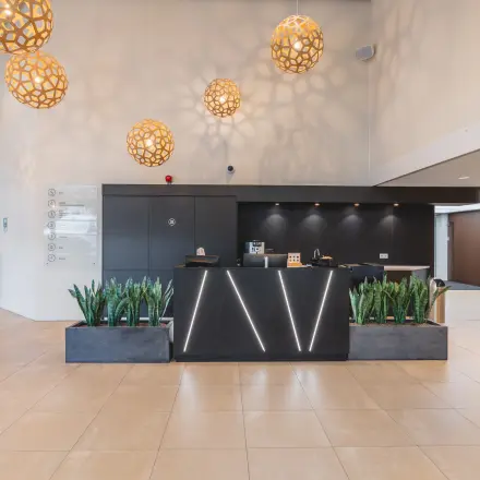 Modern office to rent at Utrecht Central Station with stylish lighting and reception desk, ideal for office space rental.