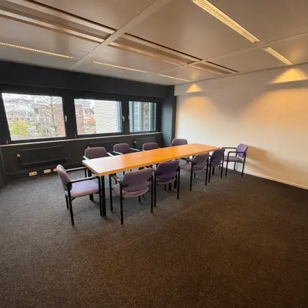Spacious office to rent in Utrecht Kanaleneiland at Bernadottelaan 13 with a large wooden table surrounded by purple chairs, ideal for meetings.