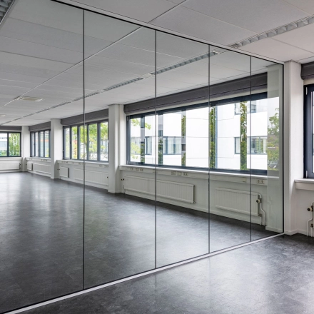 Spacious interior office space with large windows and reflective partitions, offering ample natural light at Atoomweg 350, Utrecht Lage Weide. Ideal for office space rental.