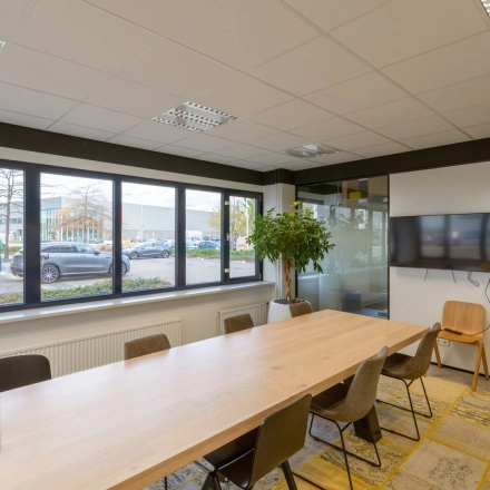 Modern office space at Atoomweg 400, Utrecht Lage Weide with a large table, chairs, and a TV, available for office space rental.
