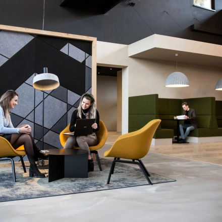 Modern office lounge at Atoomweg 63, Utrecht Lage Weide, featuring comfortable seating and individuals engaged in business activities, ideal for office space rental.