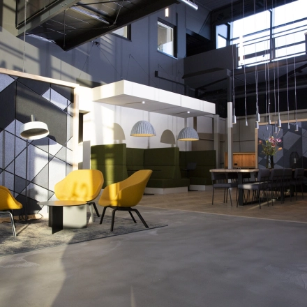 Modern office space at Atoomweg 63, Utrecht Lage Weide, featuring stylish furnishings and a professional ambiance. A person is making a phone call in the workspace area, suitable for office space rental.