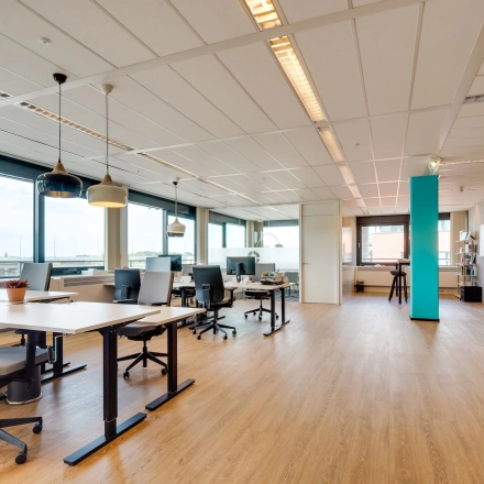 Spacious office space with desks and chairs available for rent at Computerweg 22, Utrecht Lage Weide. Large windows provide natural light.
