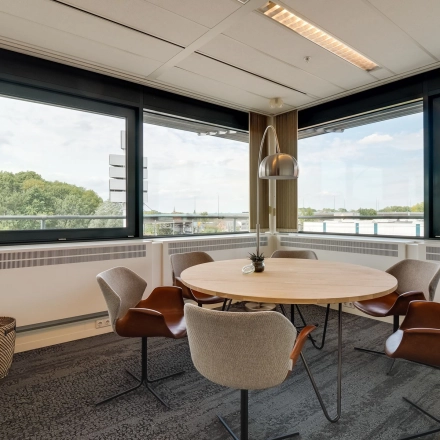 Bright office space at Computerweg 22 in Utrecht Lage Weide featuring a round table with five chairs and large windows offering ample natural light.
