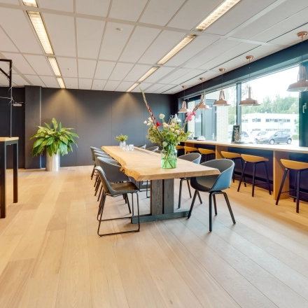 Modern office space in Utrecht Lage Weide featuring a spacious, furnished interior with large windows and a mix of seating areas, ideal for working or meetings.