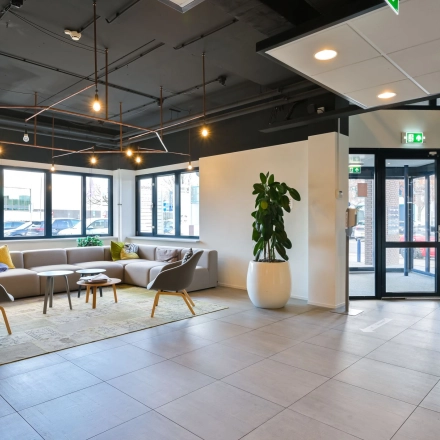 Bright and airy office entrance at Kobaltweg 11 in Utrecht Lage Weide, featuring modern seating and greenery. Ideal for office space rental.