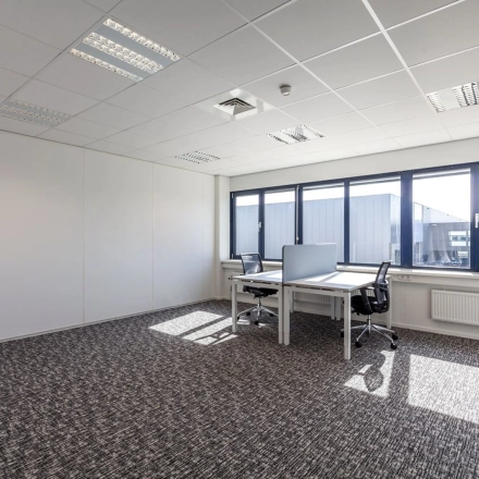 Bright office space with carpeted flooring and two desks, ideal for office space rental at Reactorweg 301, Utrecht Lage Weide.