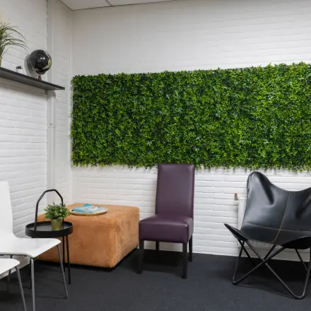 Cozy office space with seating area featuring modern chairs and a green wall decor at Zonnebaan 18, ideal for rent office space in Utrecht Lage Weide.