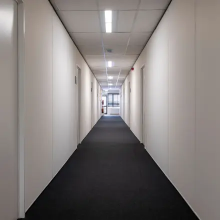 Long hallway with doors on each side, leading to office spaces for rent at Zonnebaan 18 in Utrecht Lage Weide.