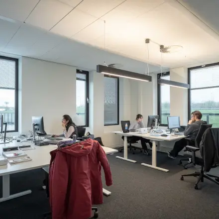 Modern office space in Utrecht Papendorp with desks and computers, featuring employees working on computers.