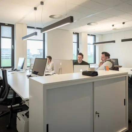 Bright, furnished office space at Van Deventerlaan 31-51, Utrecht Papendorp, featuring modern workstations and professionals collaborating. Ideal office space rental opportunity.