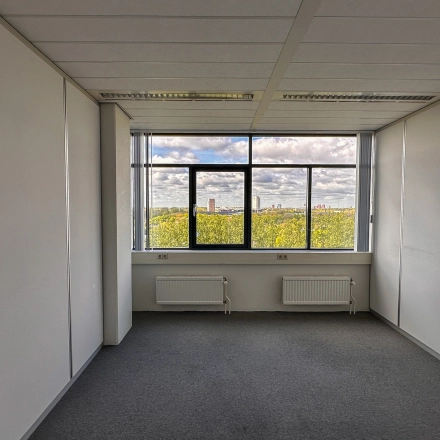 Bright office space at Daltonlaan 200, Utrecht Rijnsweerd, featuring a large window with a view of the city skyline, ideal for office space rental.