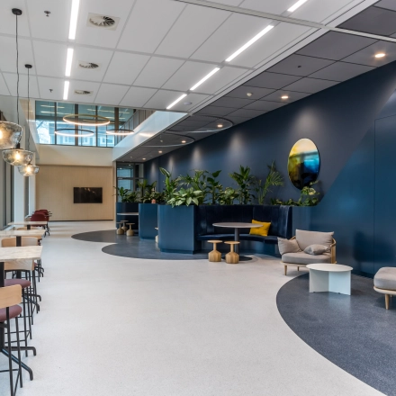 Modern office located at Vliegend Hertlaan 15, Utrecht South, with stylish furnishings including seating areas and lush greenery, ideal for office space rental.