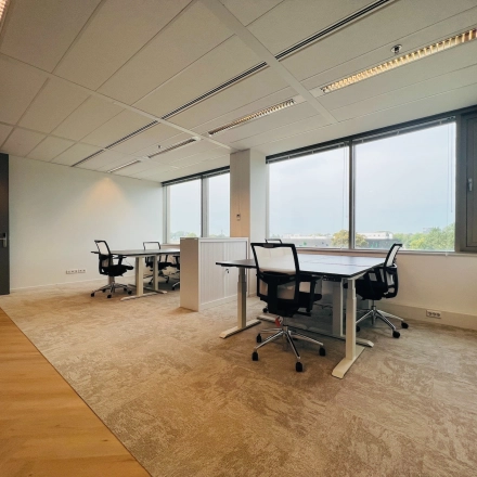 Furnished office space for rent in Utrecht South at Vliegend Hertlaan 15, featuring large windows and modern desks with chairs, ideal for workspace needs.