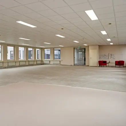 Spacious, unfurnished office space in Veldhoven located at De Run 4312, featuring large windows and ample lighting, ideal for customizing workstations in a professional setting.
